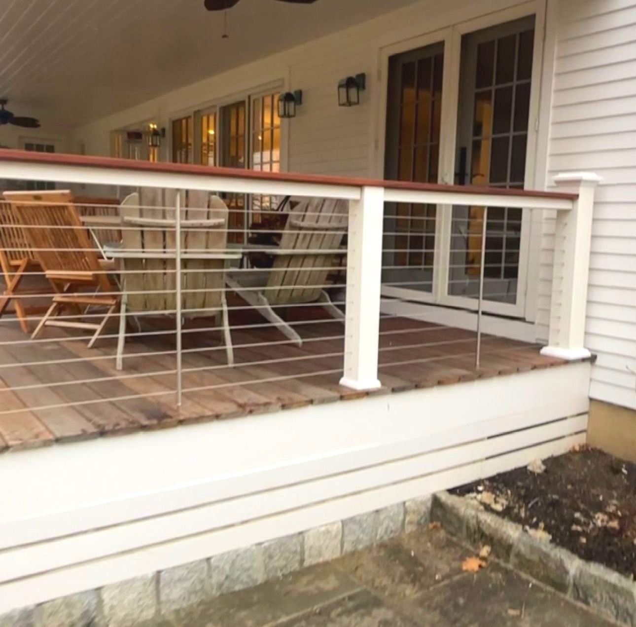 A wooden deck with a stainless steel railing