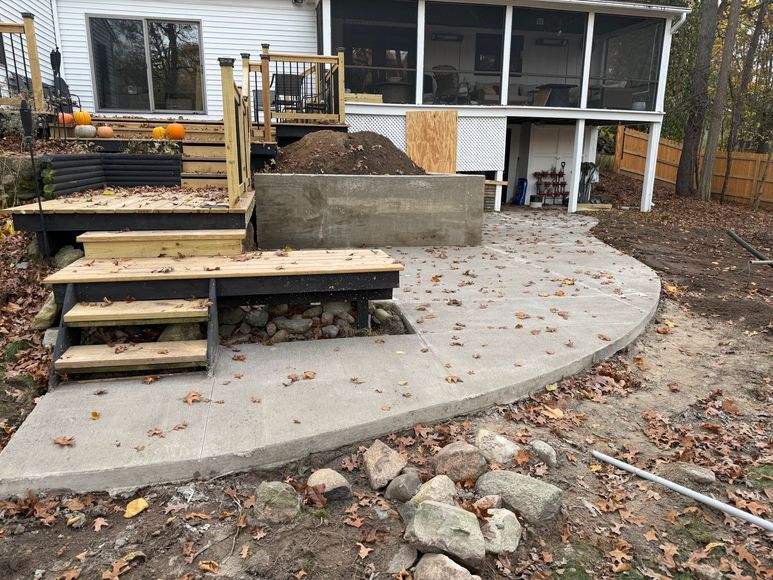 A house with a screened in porch and a concrete patio in front of it.