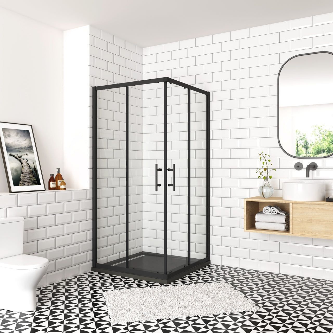 Bagno moderno con doccia in vetro con cornice nera, piastrelle bianche tipo metropolitana, pavimento decorato e mobile lavabo in legno.