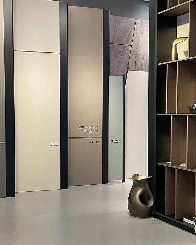 Showroom moderno con pannelli a parete alti, scaffalature e una piccola scultura decorativa sul pavimento.