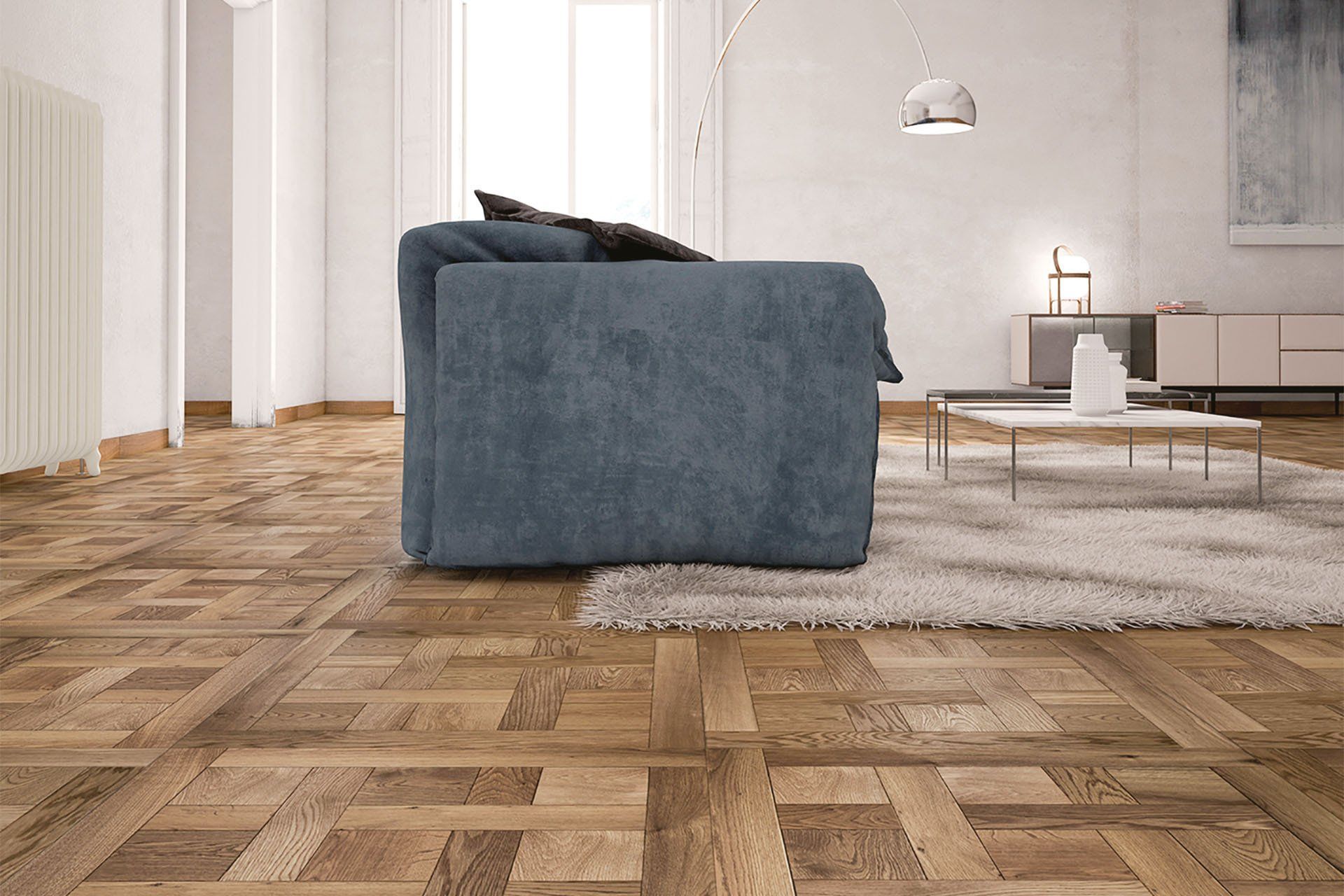 Soggiorno moderno con divano blu, pavimento in parquet e tappeto chiaro.