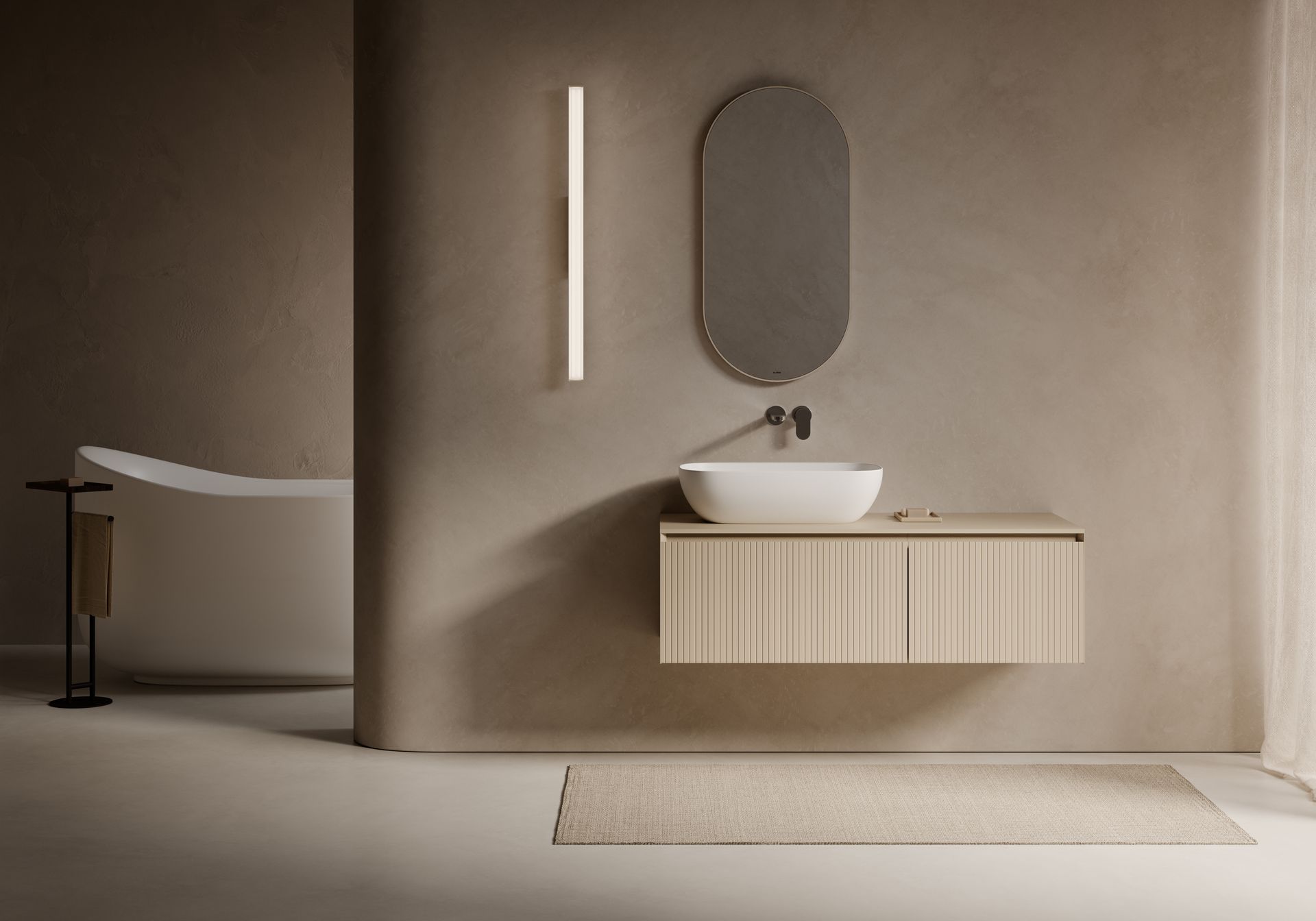 Bagno minimalista sui toni del beige con mobile lavabo sospeso, specchio ovale, applique, vasca e tappeto.