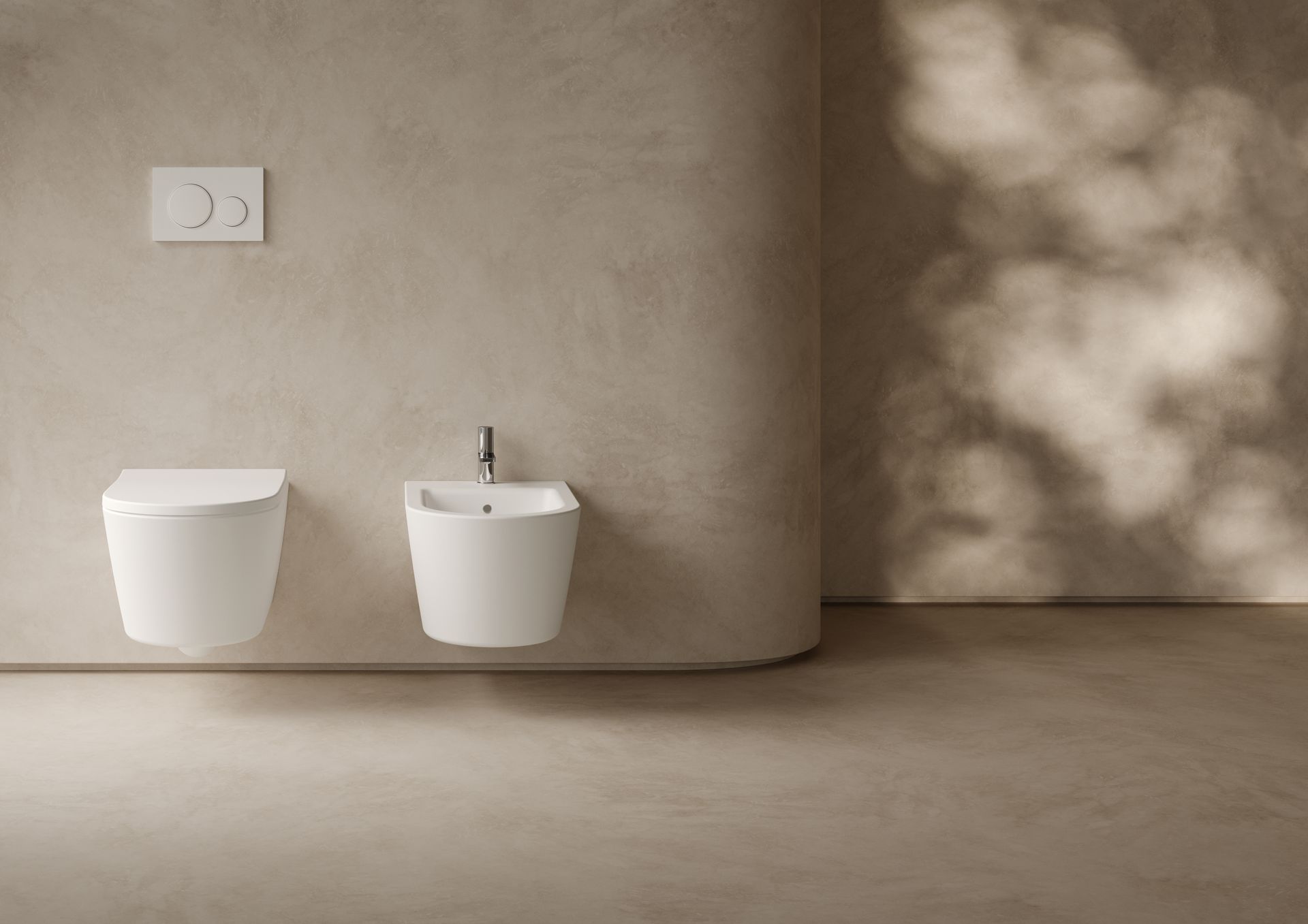 Bagno minimalista sui toni del beige con due WC sospesi bianchi e delicate ombre proiettate dalle finestre sulla parete.