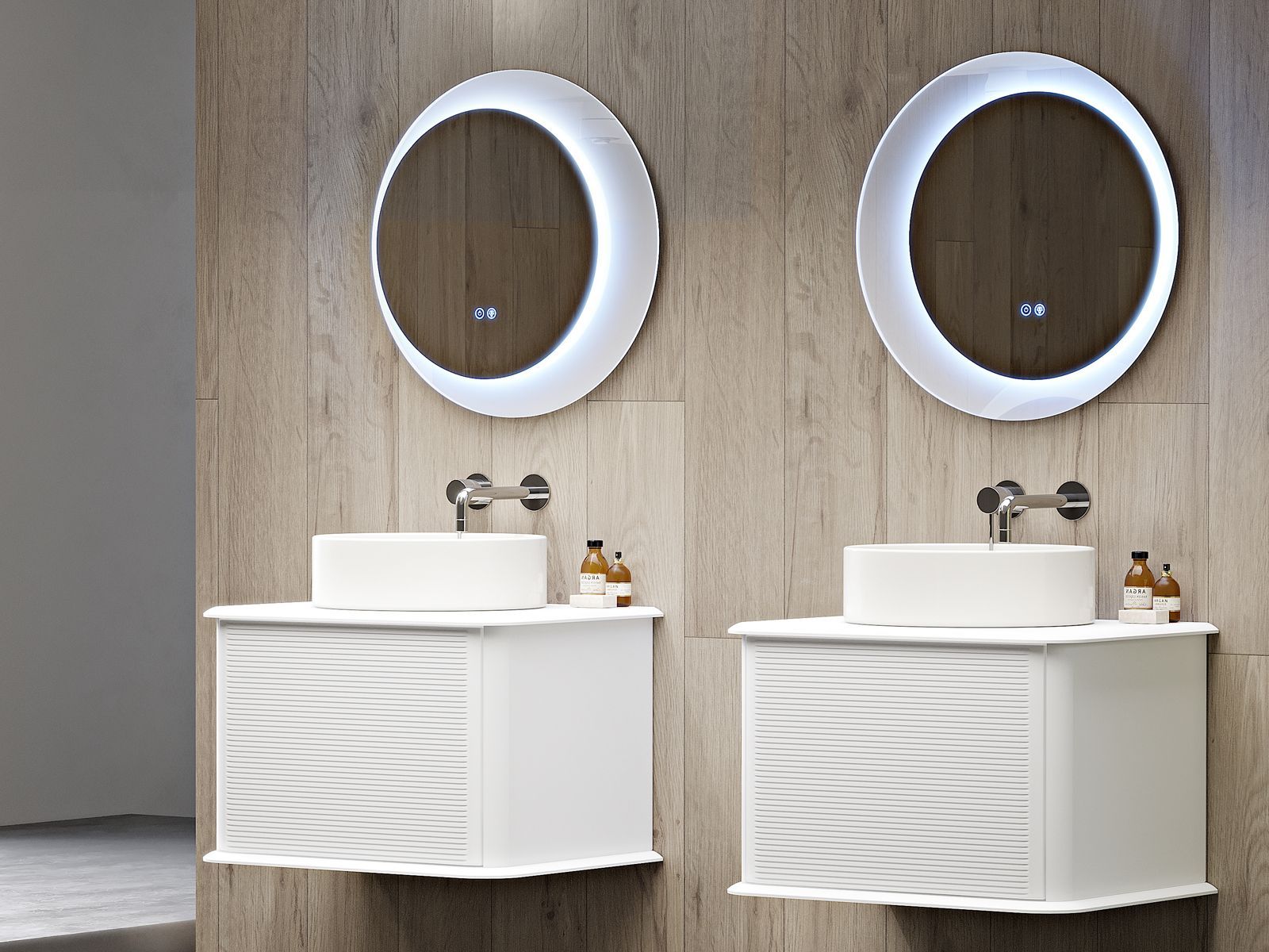 Due lavabi bianchi con specchi ovali su una parete del bagno rivestita in legno.