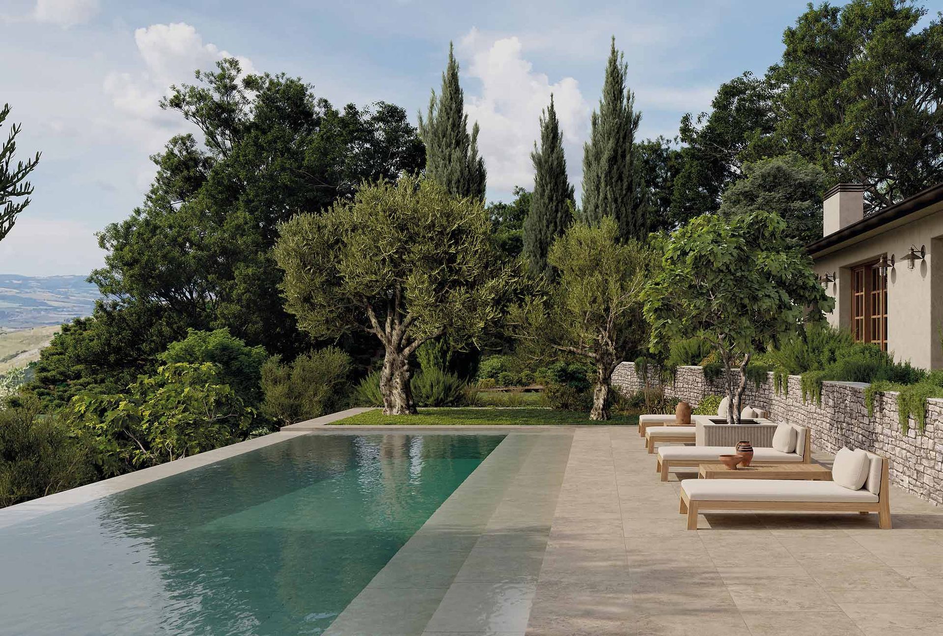 Piscina moderna nel cortile sul retro con lettini prendisole, patio in pietra e alberi rigogliosi accanto alla casa