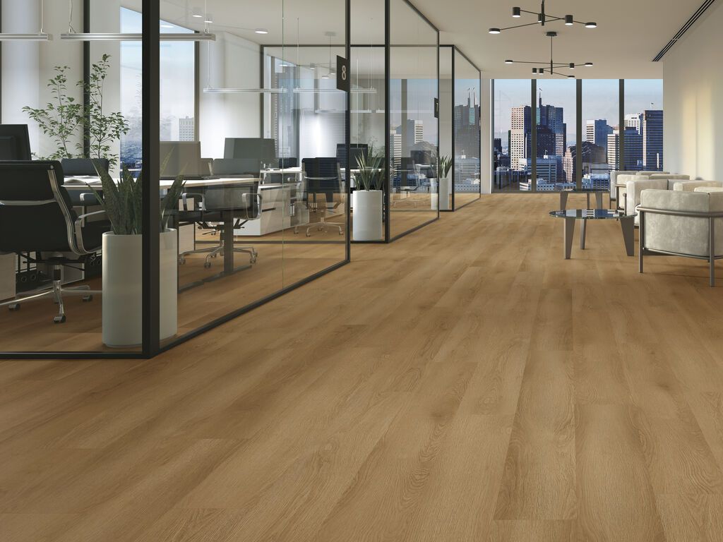 Ufficio moderno open space con pareti in vetro, scrivanie, area lounge e vista sullo skyline della città.