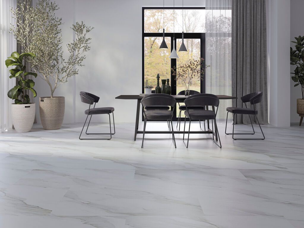 Sala da pranzo moderna con tavolo nero, sedie abbinate, lampade a sospensione e grandi finestre con vista sugli alberi all'esterno.