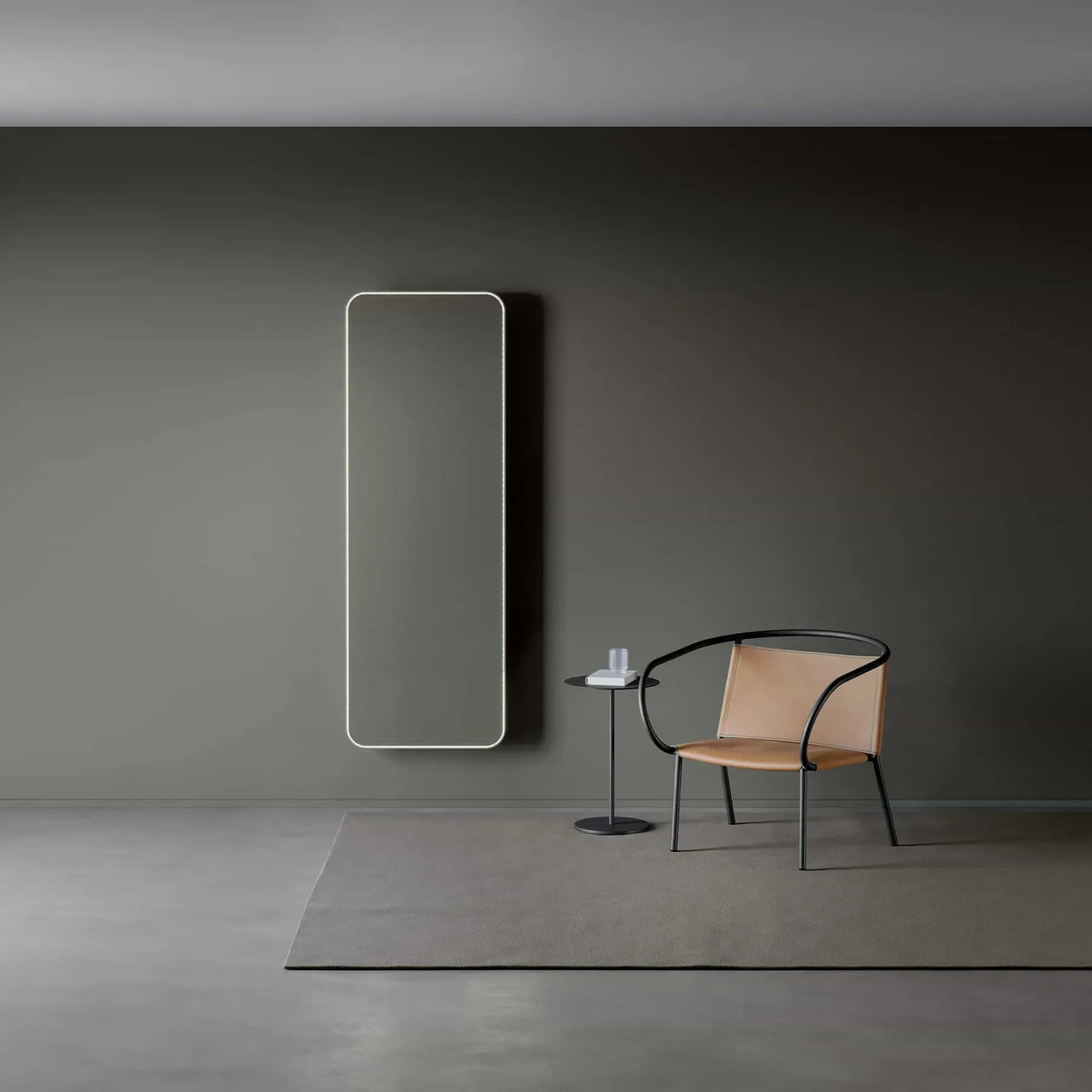 Stanza minimalista grigia con specchio a parete, tavolino e sedia nera con cuscino beige su un tappeto.