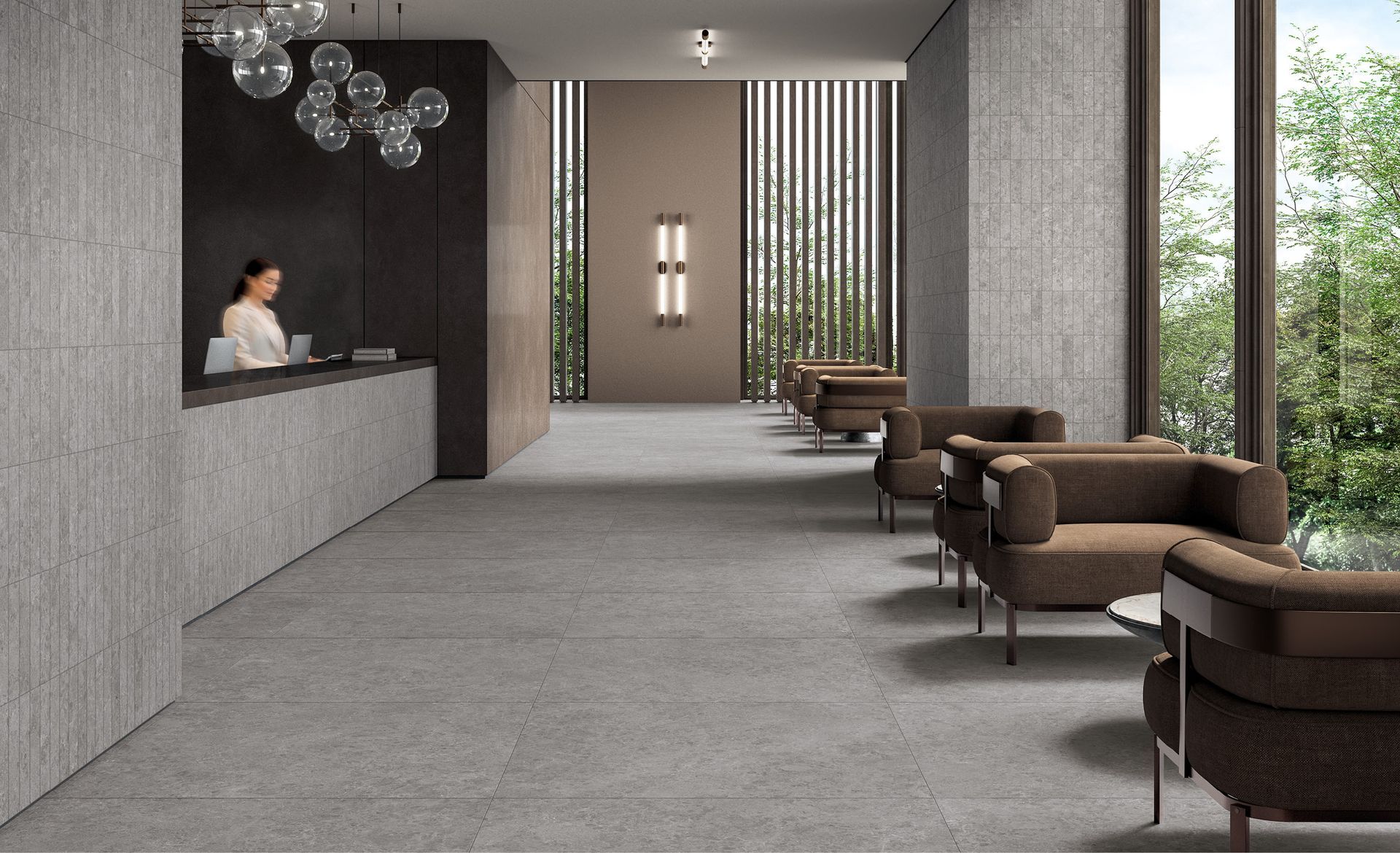 Hall moderna dell'hotel con reception, poltrone e ampie finestre che si affacciano sul verde.