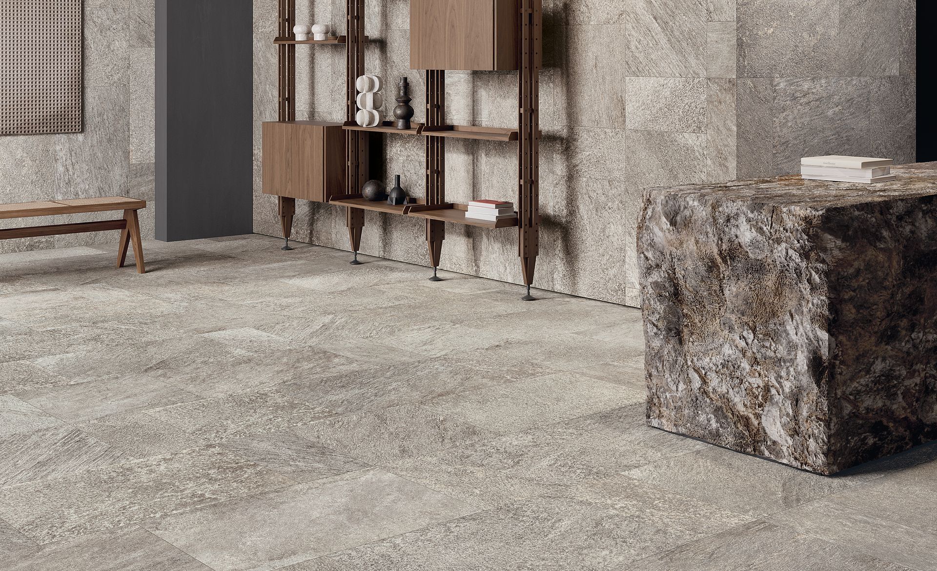 Interno minimalista con pavimento in cemento, scaffali in legno e sgabello in blocco di pietra.