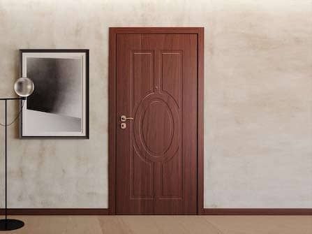 Stanza minimalista con porta in legno, quadri incorniciati e lampada da terra su una parete beige.
