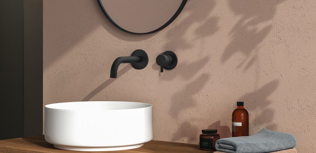 Lavabo del bagno con rubinetto nero, lavabo bianco e accessori da bagno su un ripiano in legno.