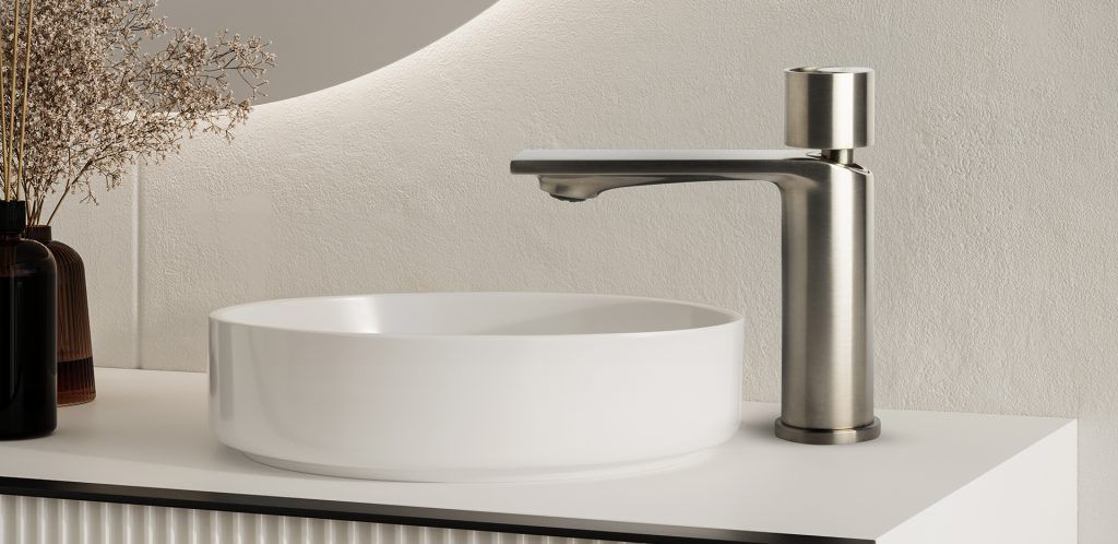 Lavabo moderno con vasca bianca e rubinetto cromato su piano di lavoro bianco.