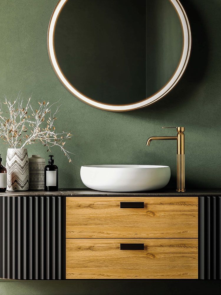 Mobile bagno moderno con specchio rotondo, lavabo bianco, cassetti in legno e parete verde.