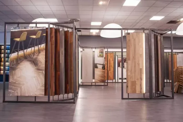Galleria d'arte moderna con grandi installazioni tessili incorniciate e pavimento lucido sotto luminose luci a soffitto.
