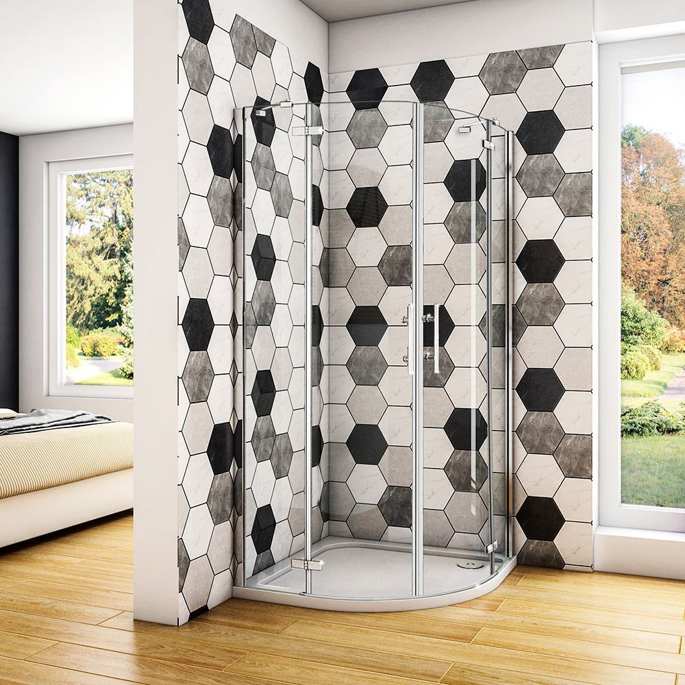 Bagno moderno con box doccia in vetro curvo e pareti rivestite con piastrelle esagonali nere, bianche e grigie.