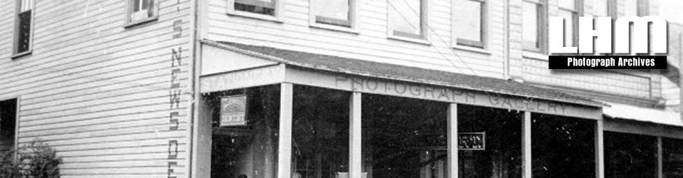 A black and white photo of a building with a sign on it