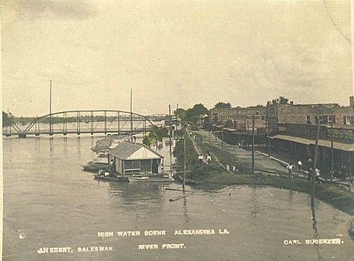 A black and white photo of a bridge over a river.
