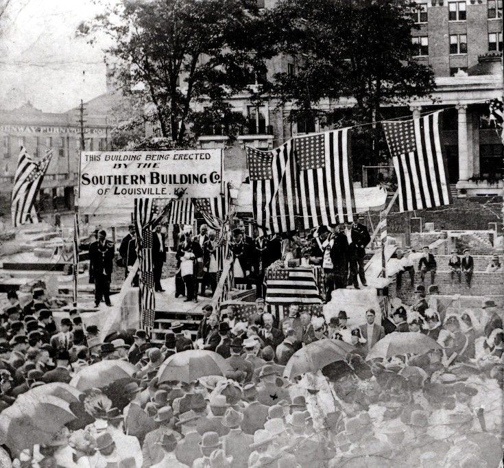A crowd of people gathered in front of a sign that says southern building co