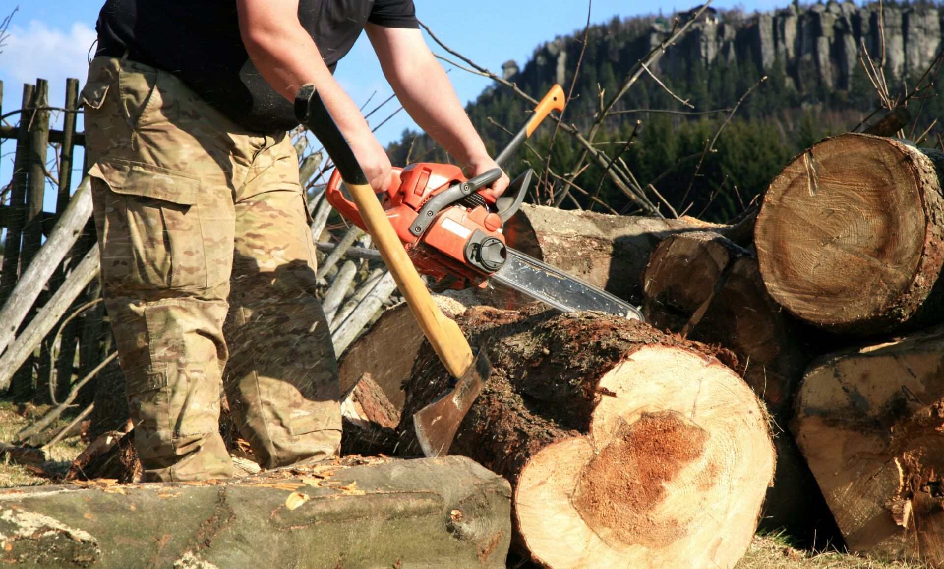 A man is cutting a log with a chainsaw