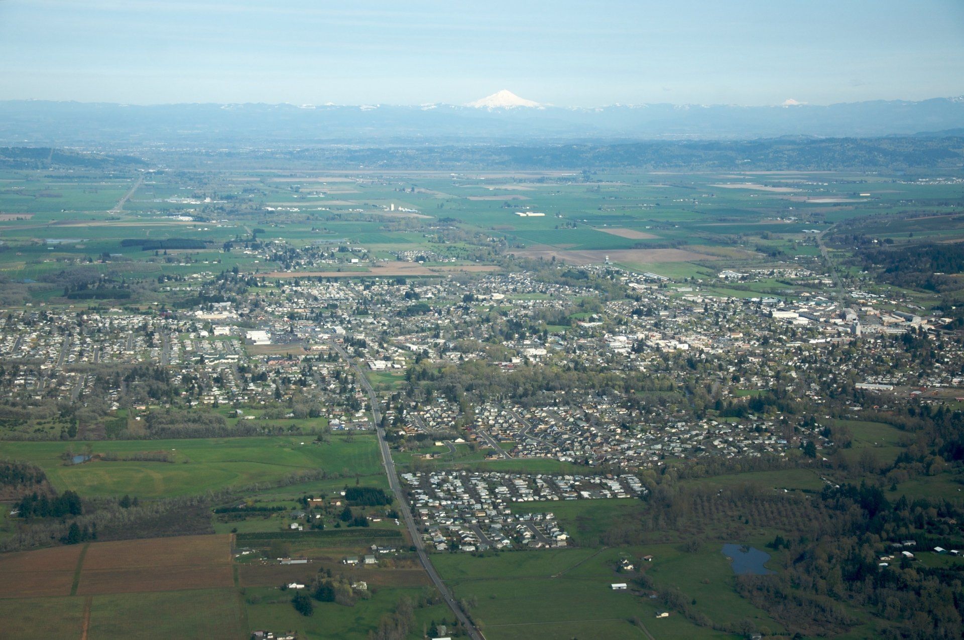 An aerial view of a small town with mountains in the background.