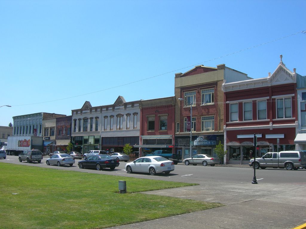Cars are driving down a street in a small town
