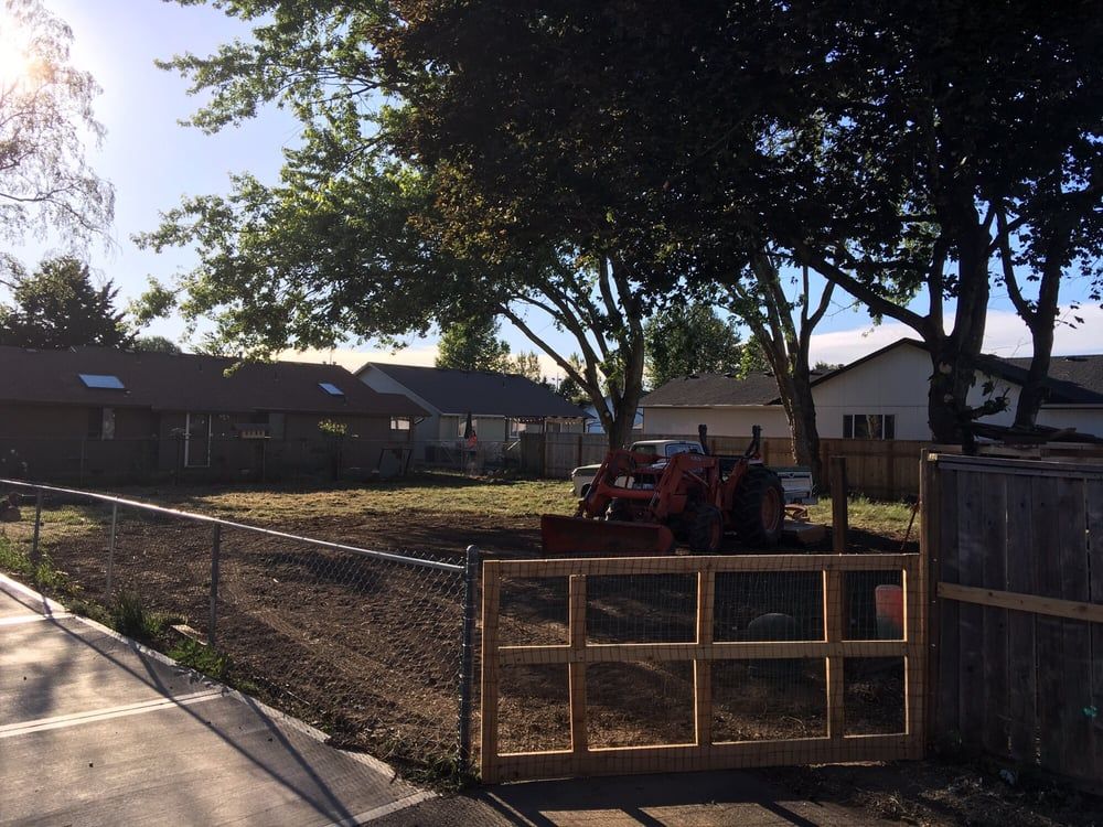 A tractor is parked in front of a wooden gate