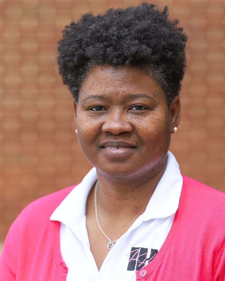 A woman wearing a pink shirt with the letter w on it