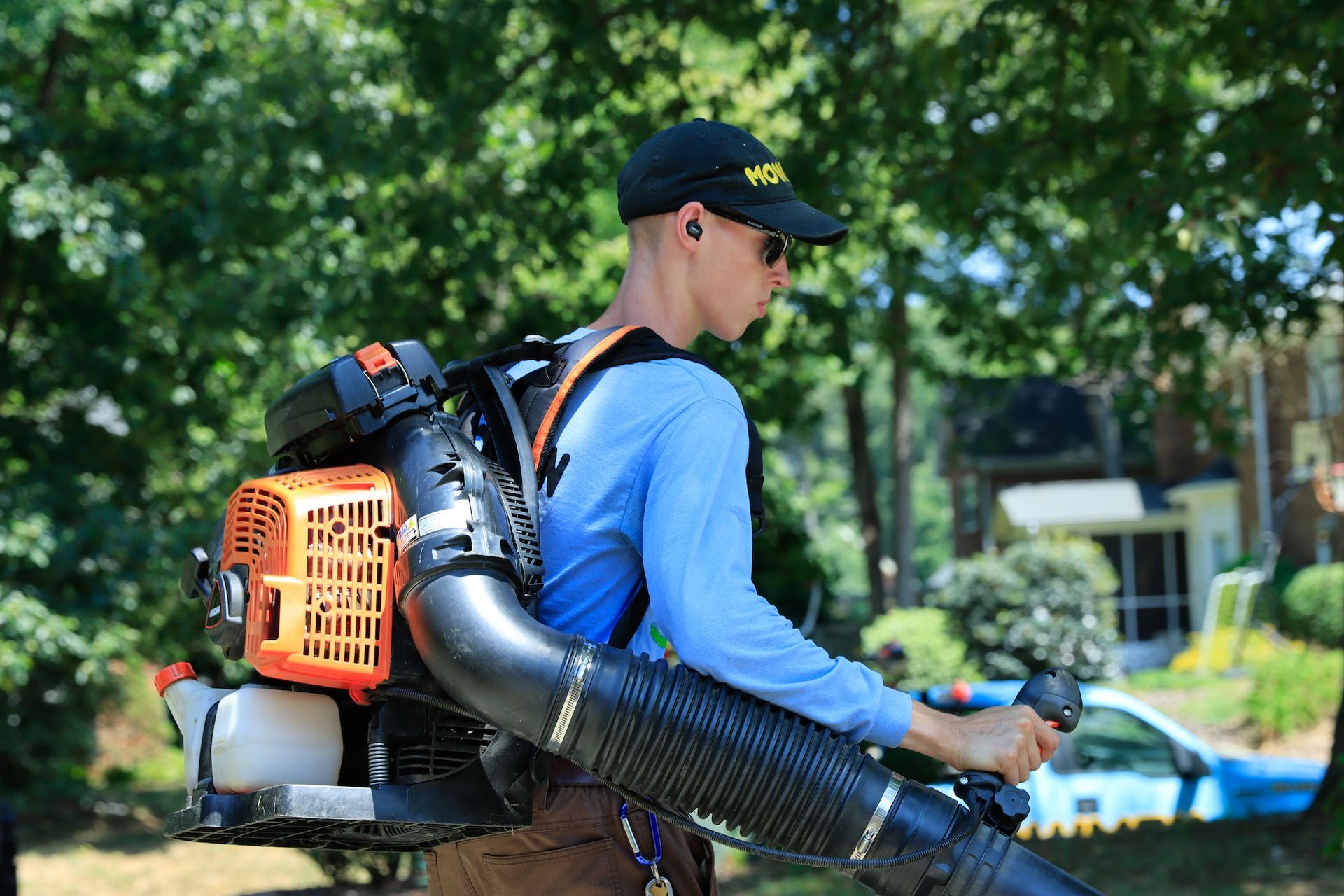 Employee getting a leaf blower out of the back of truck