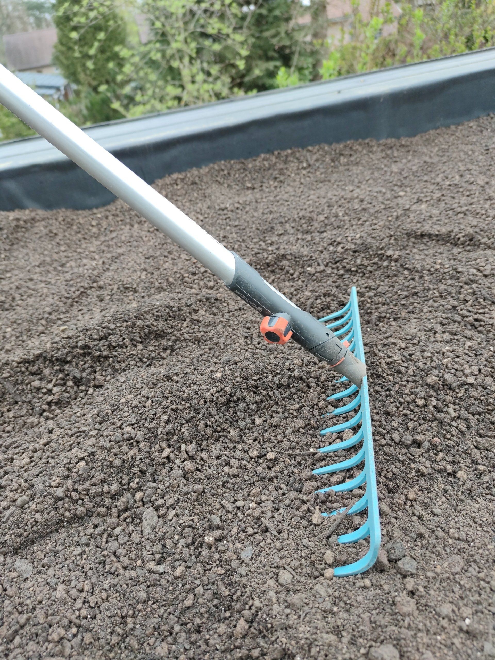 We willen natuurlijk een mooi recht groendak! Daarom rijven we het mooi glad.