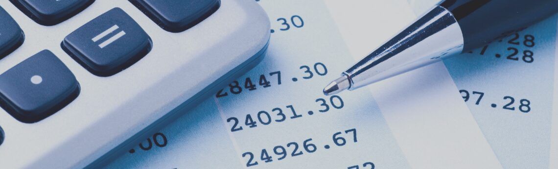 Calculator and pen on financial documents.