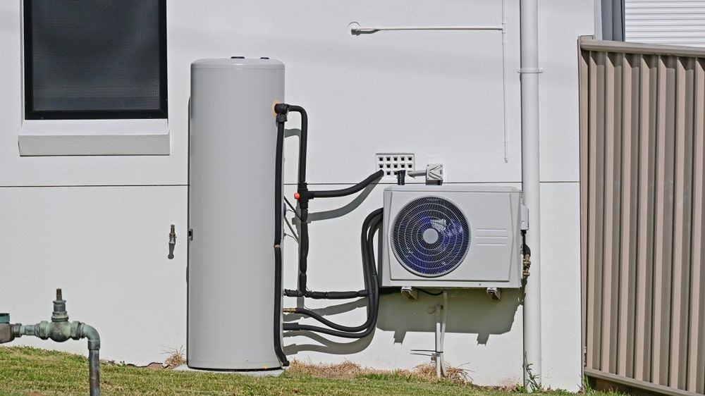 A white house with a water heater and air conditioner on the side of it — AC Electrical & Air In Bundaberg Central, QLD