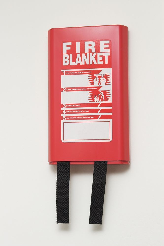 A Red Fire Blanket Is Hanging On A White Wall — Northern Testing in Winnellie, NT