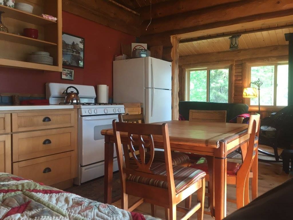 A kitchen with a table and chairs and a refrigerator.