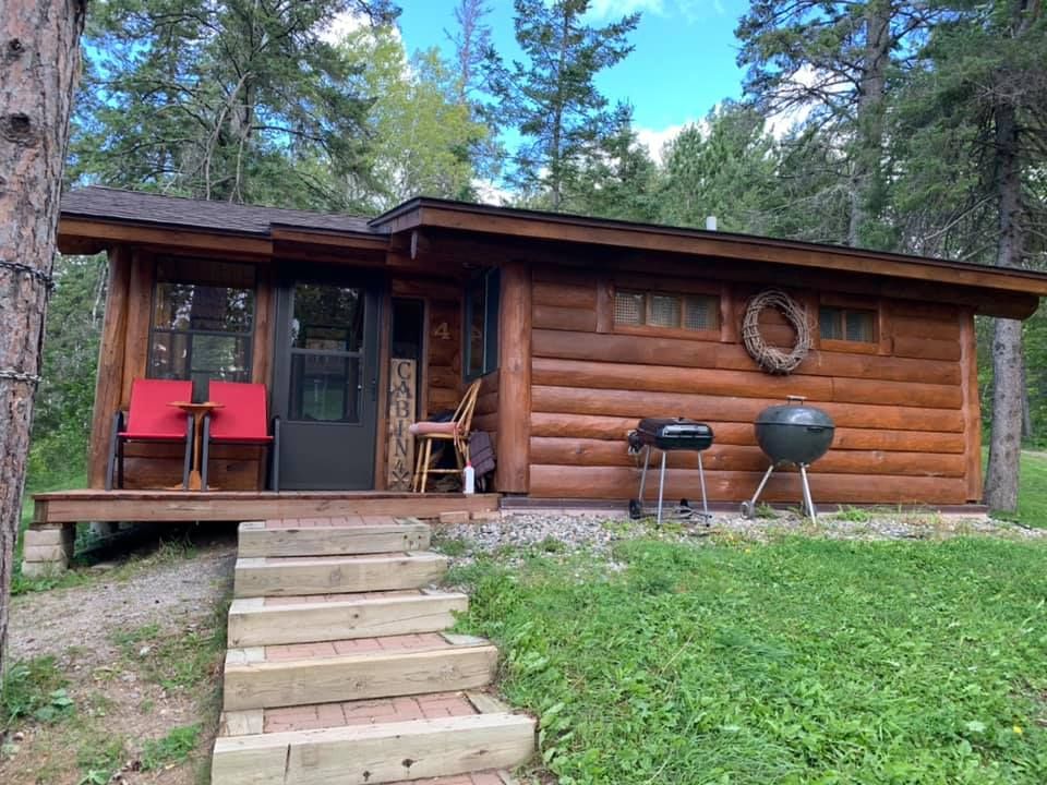 A small log cabin with stairs leading up to it.