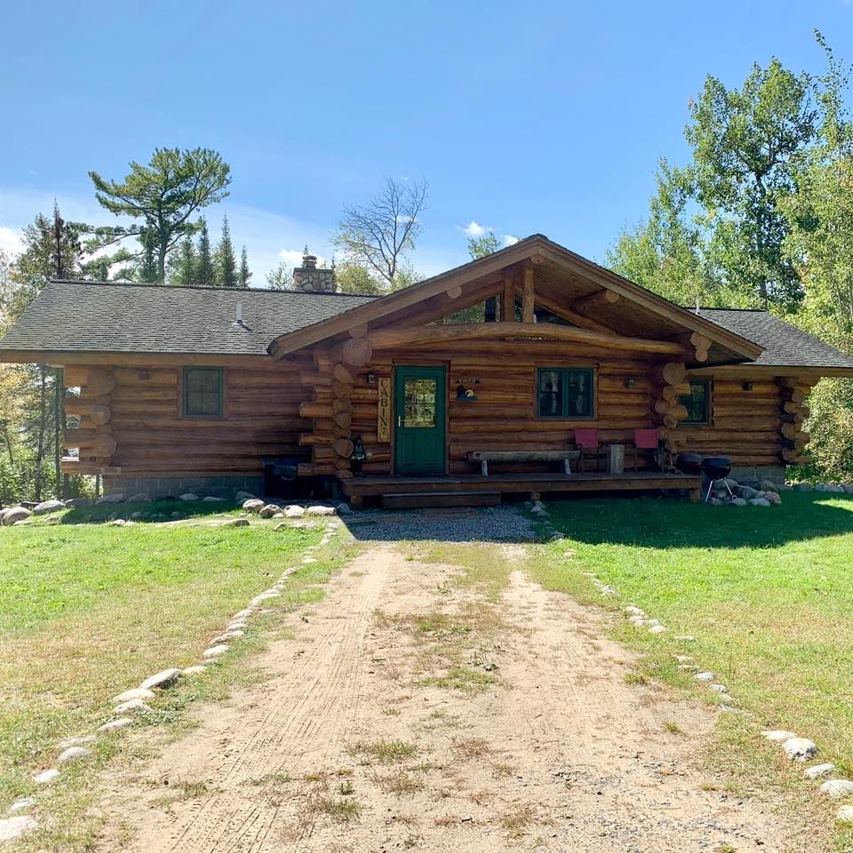 A log cabin in the middle of a grassy field