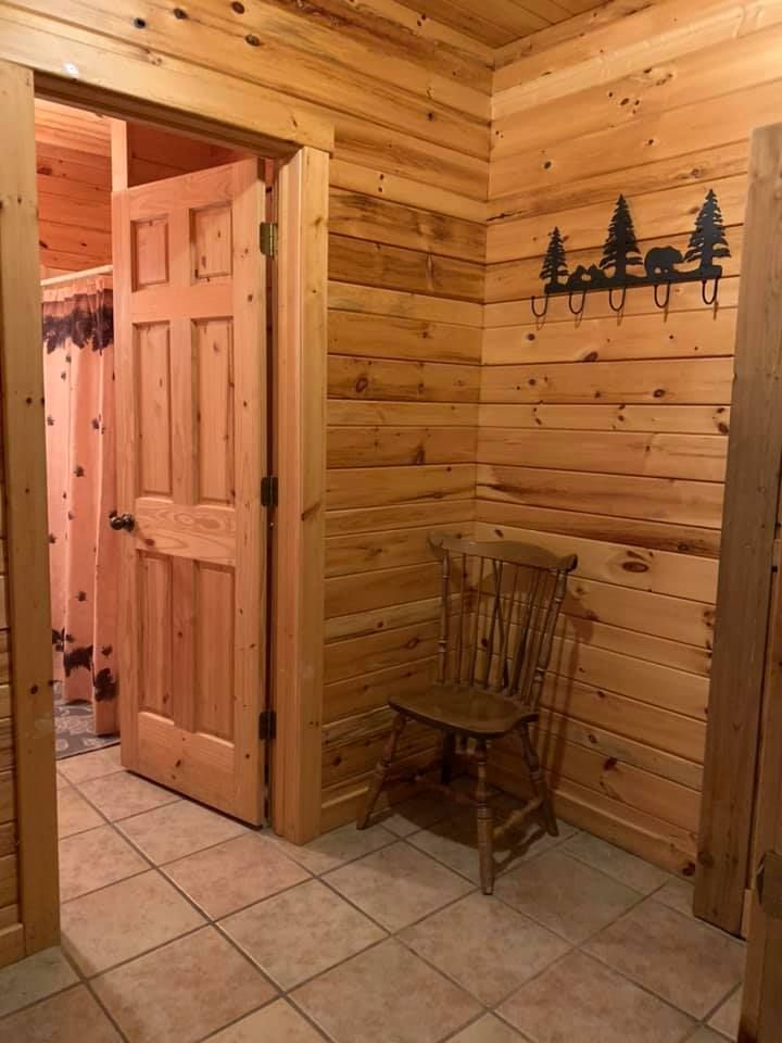A wooden chair is sitting in a hallway next to a wooden door.
