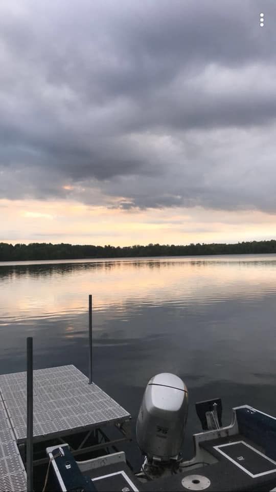 A boat is docked at a dock on a lake.
