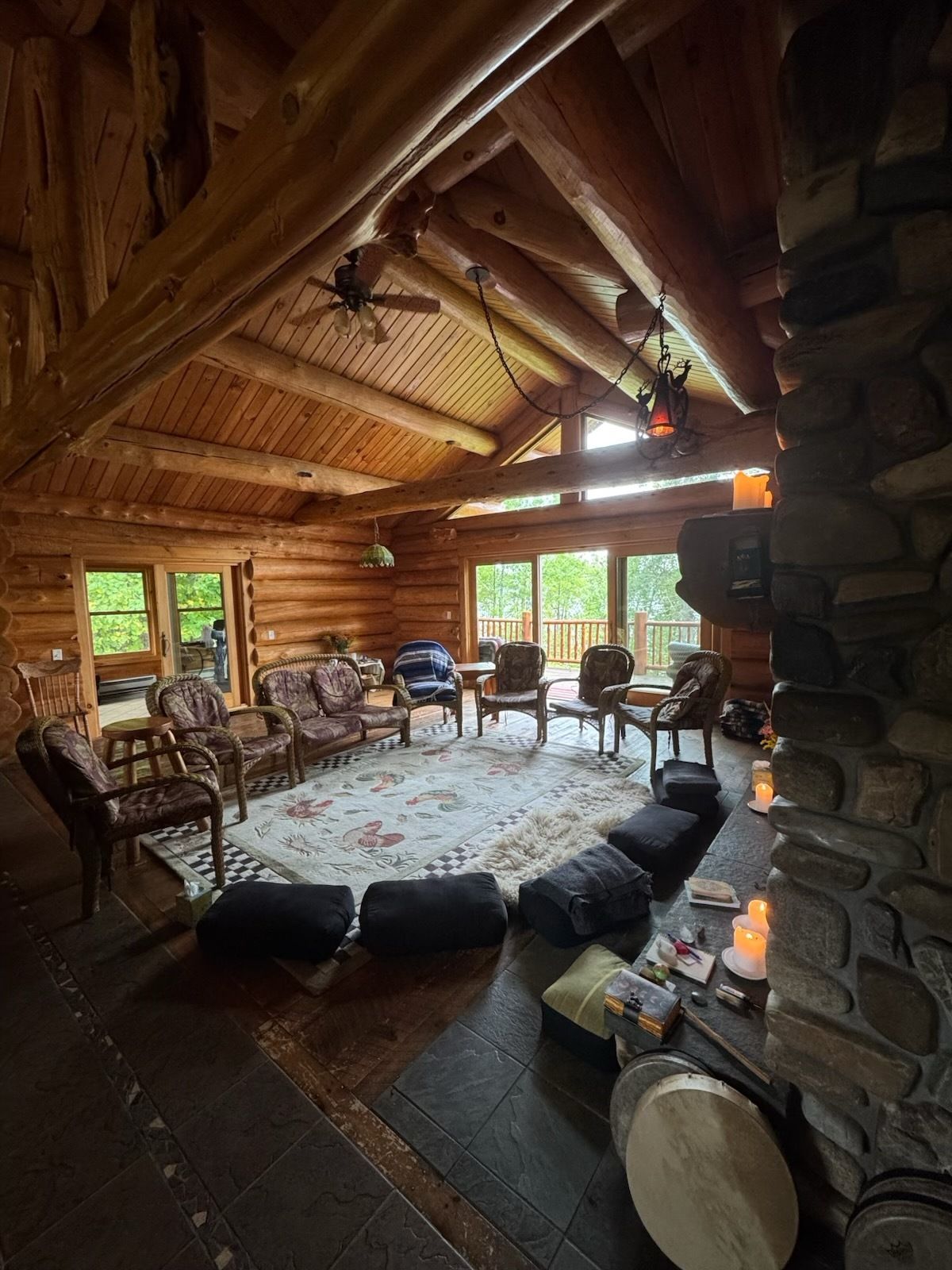 A living room in a log cabin with a couch and chairs