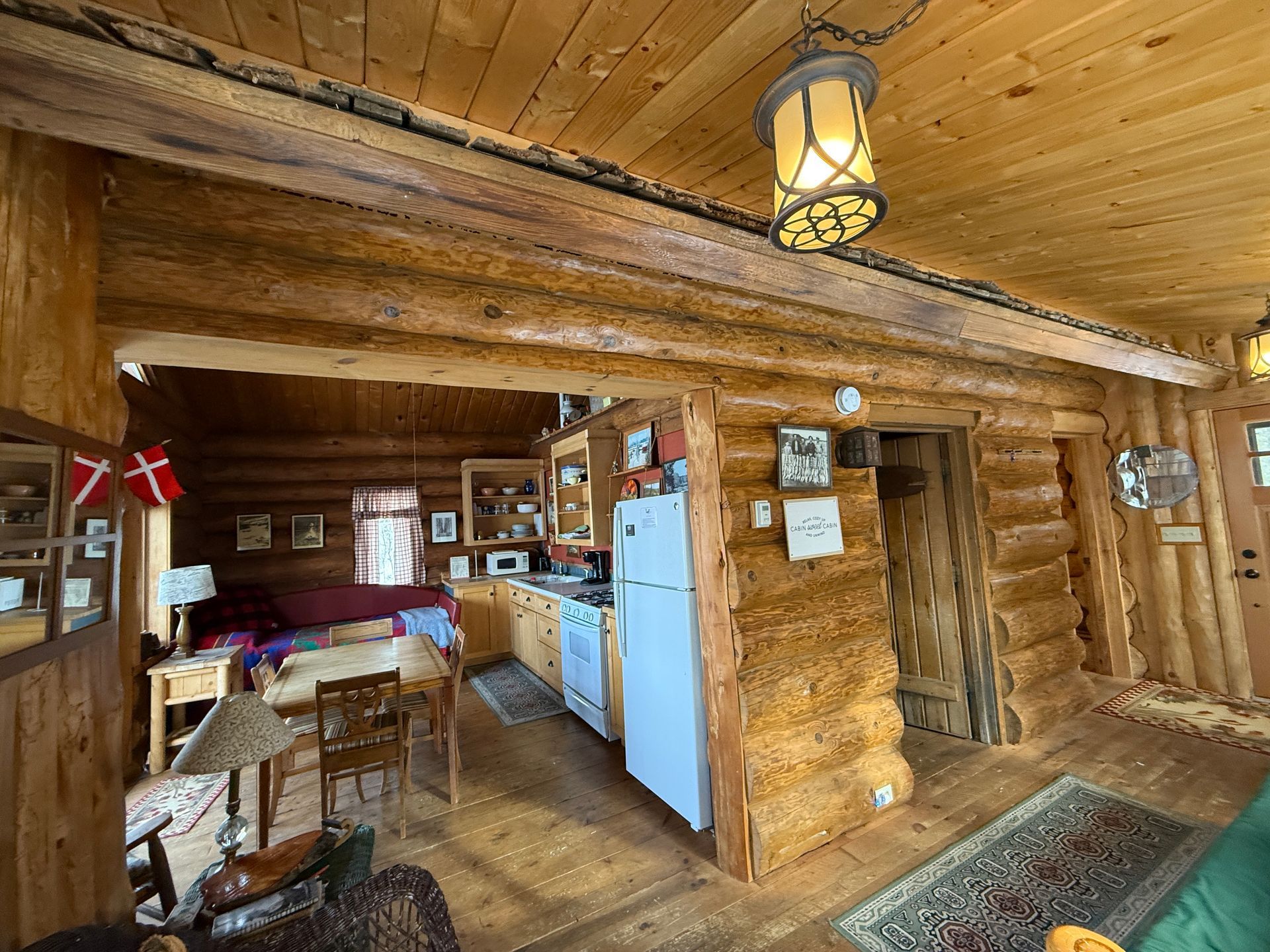 A bedroom in a log cabin with a bed and two lamps.