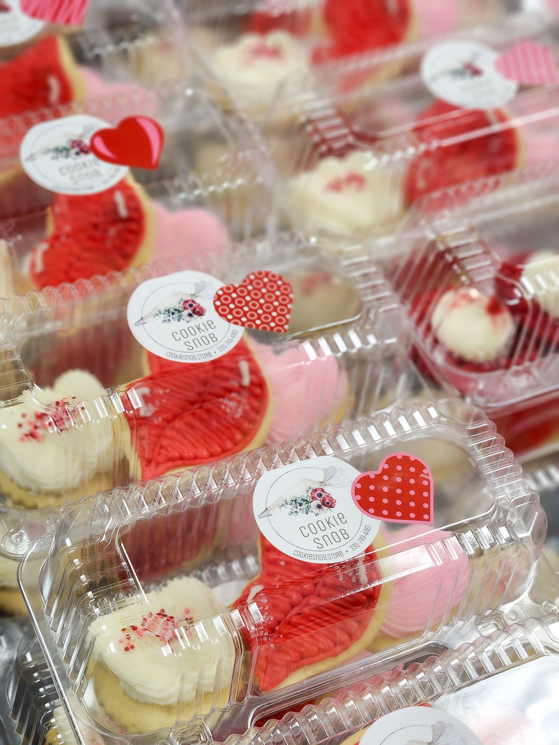 A box of cookies with white frosting and nuts on top.