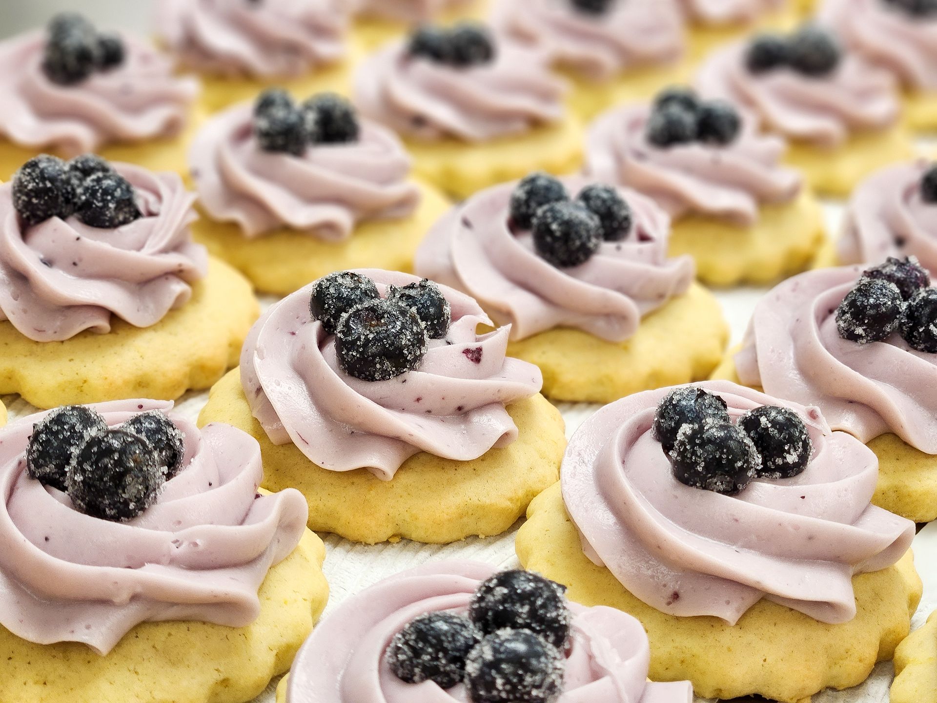 Cookies decorated with green frosting shamrocks, rainbow sprinkles, and white frosting.