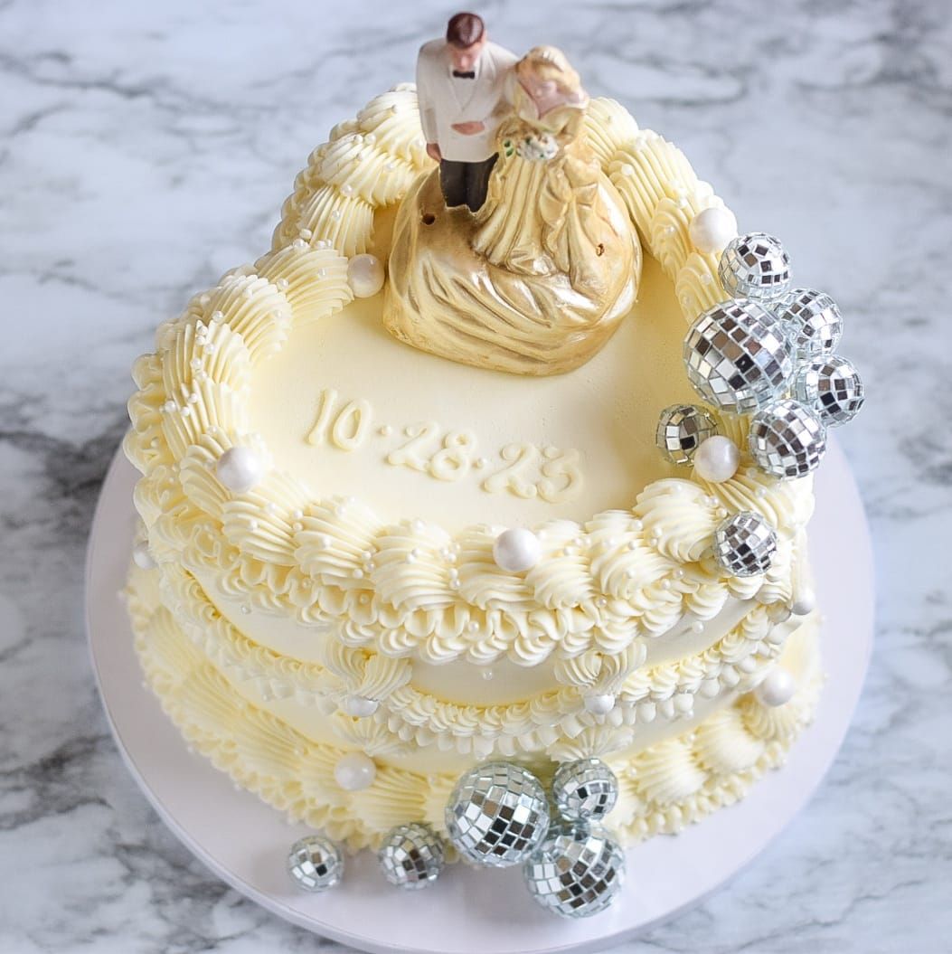 A wedding cake with a bride and groom figurine on top