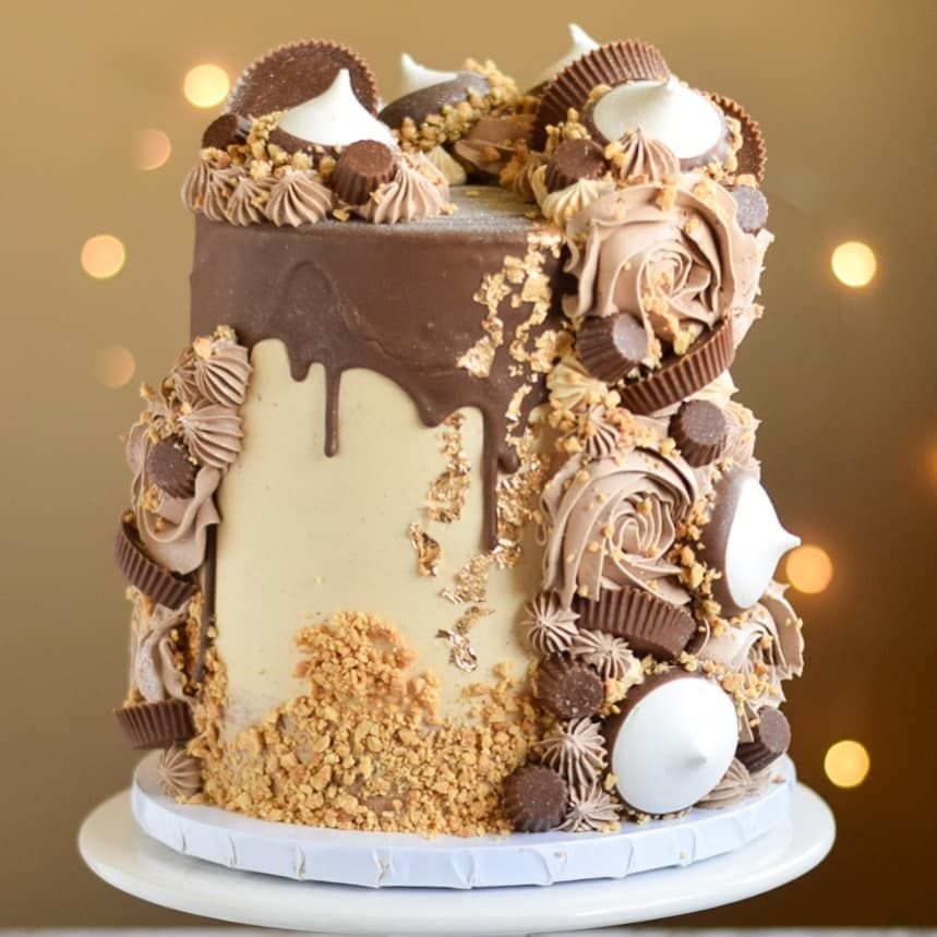 A chocolate cake with peanut butter cups and meringue on top