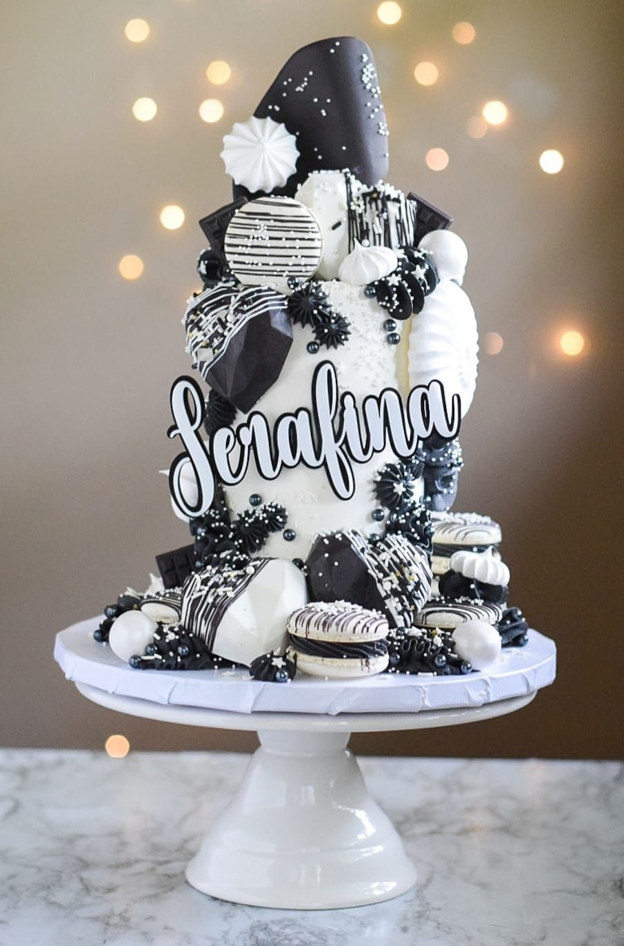 A black and white cake with the name serafina on it