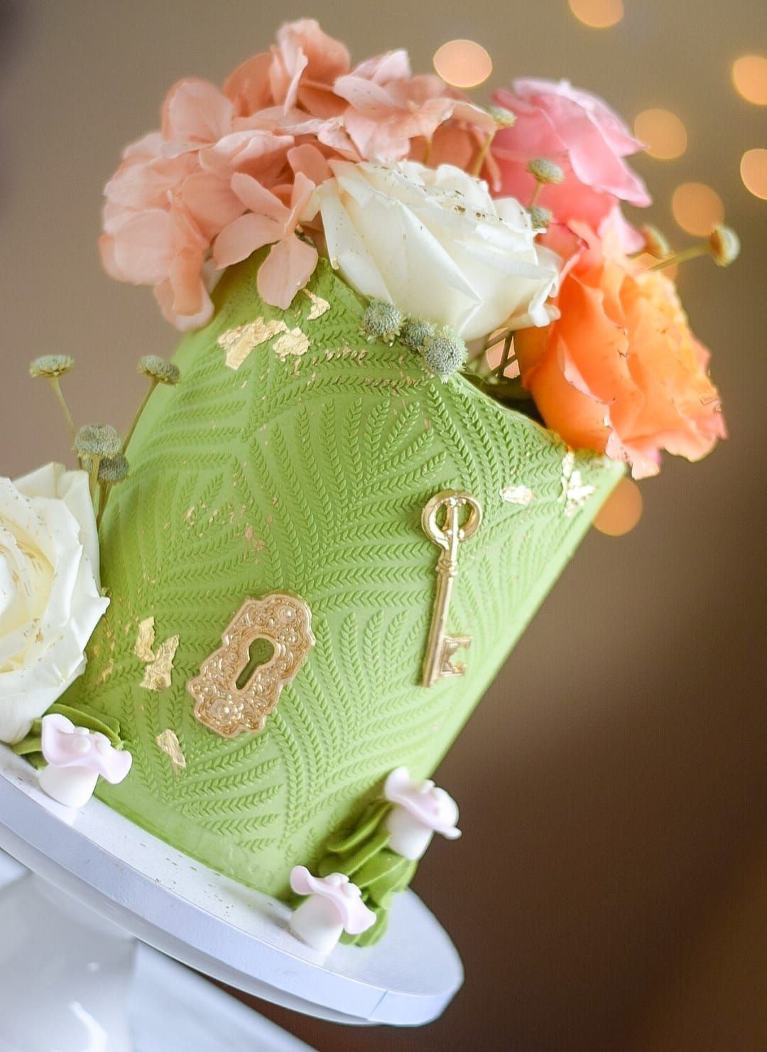 A green cake with flowers and a key on it