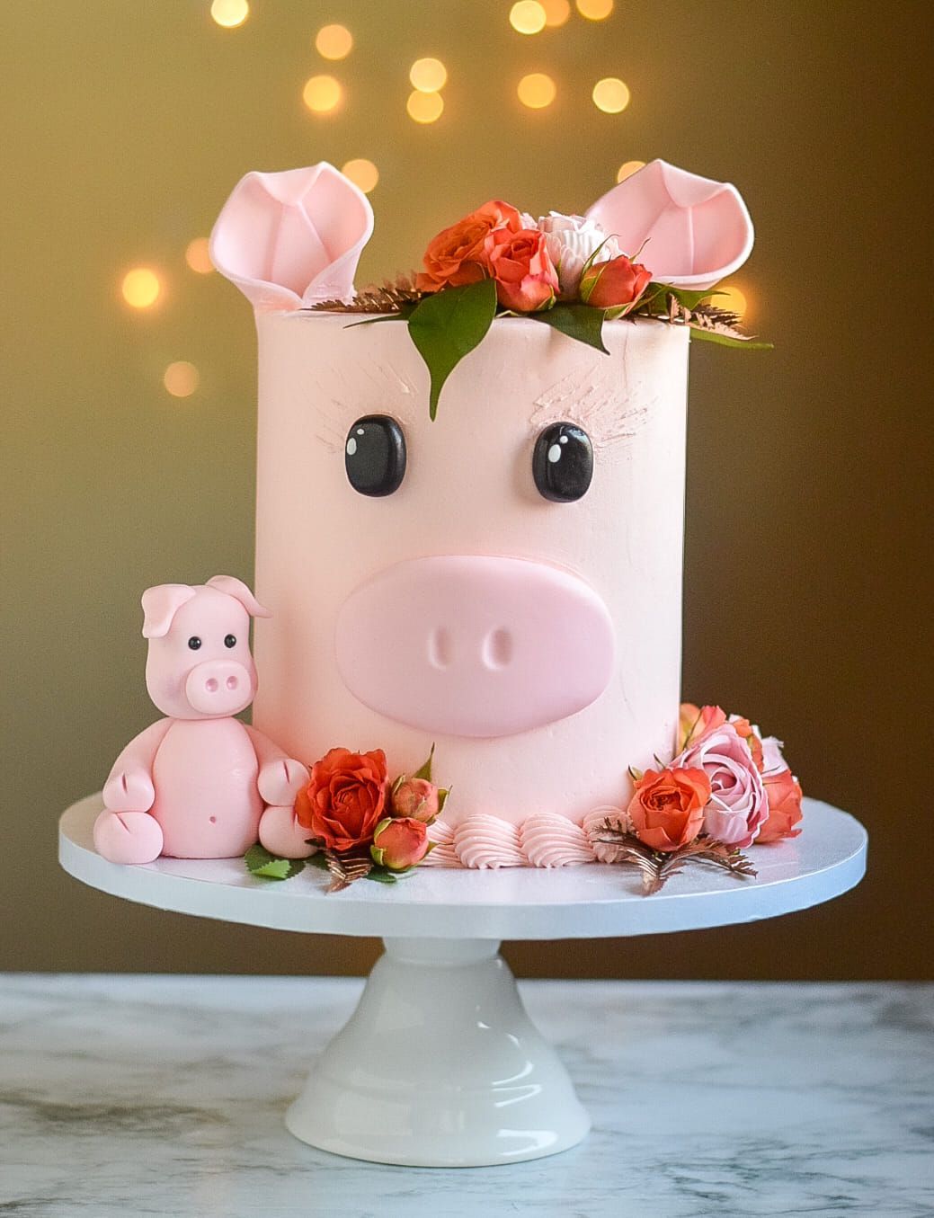 A cake in the shape of a pig with flowers on it