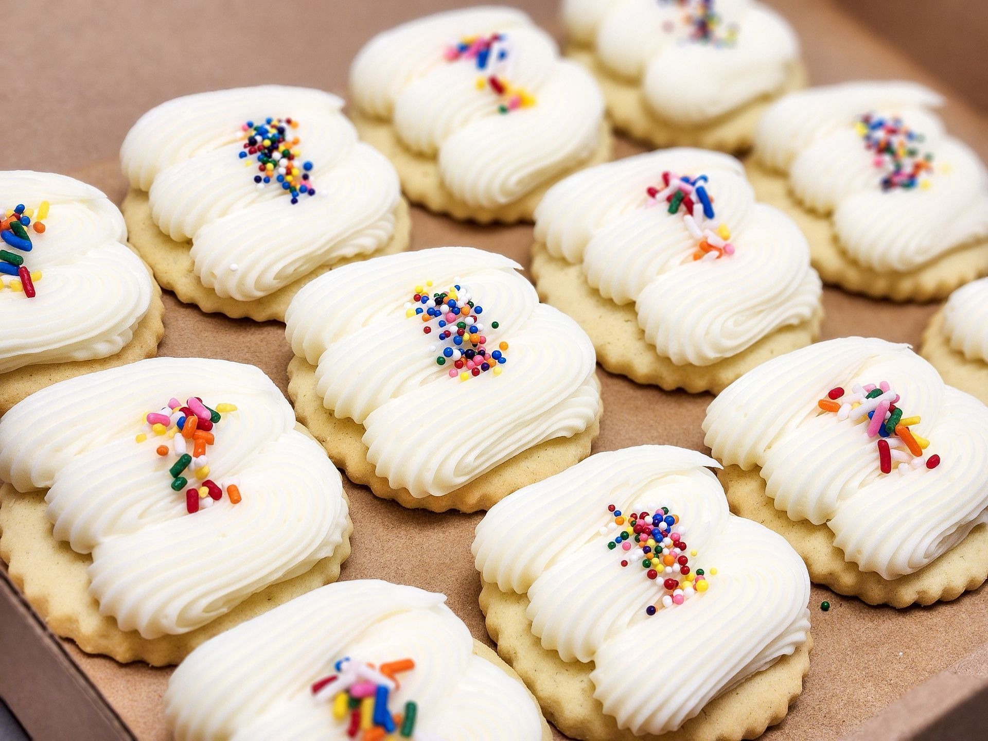 A box of cookies with frosting and sprinkles on them