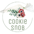 The logo for cookie snob shows a piping bag with flowers on it.