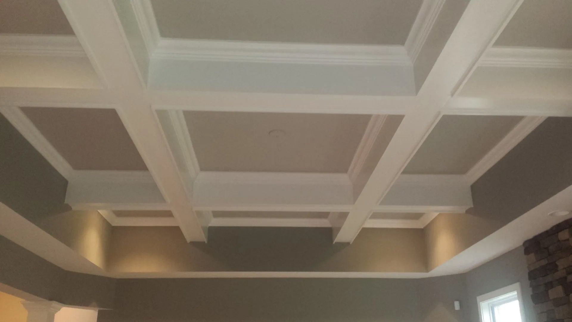 Coffered ceiling with white trim and recessed lighting in a room with gray walls